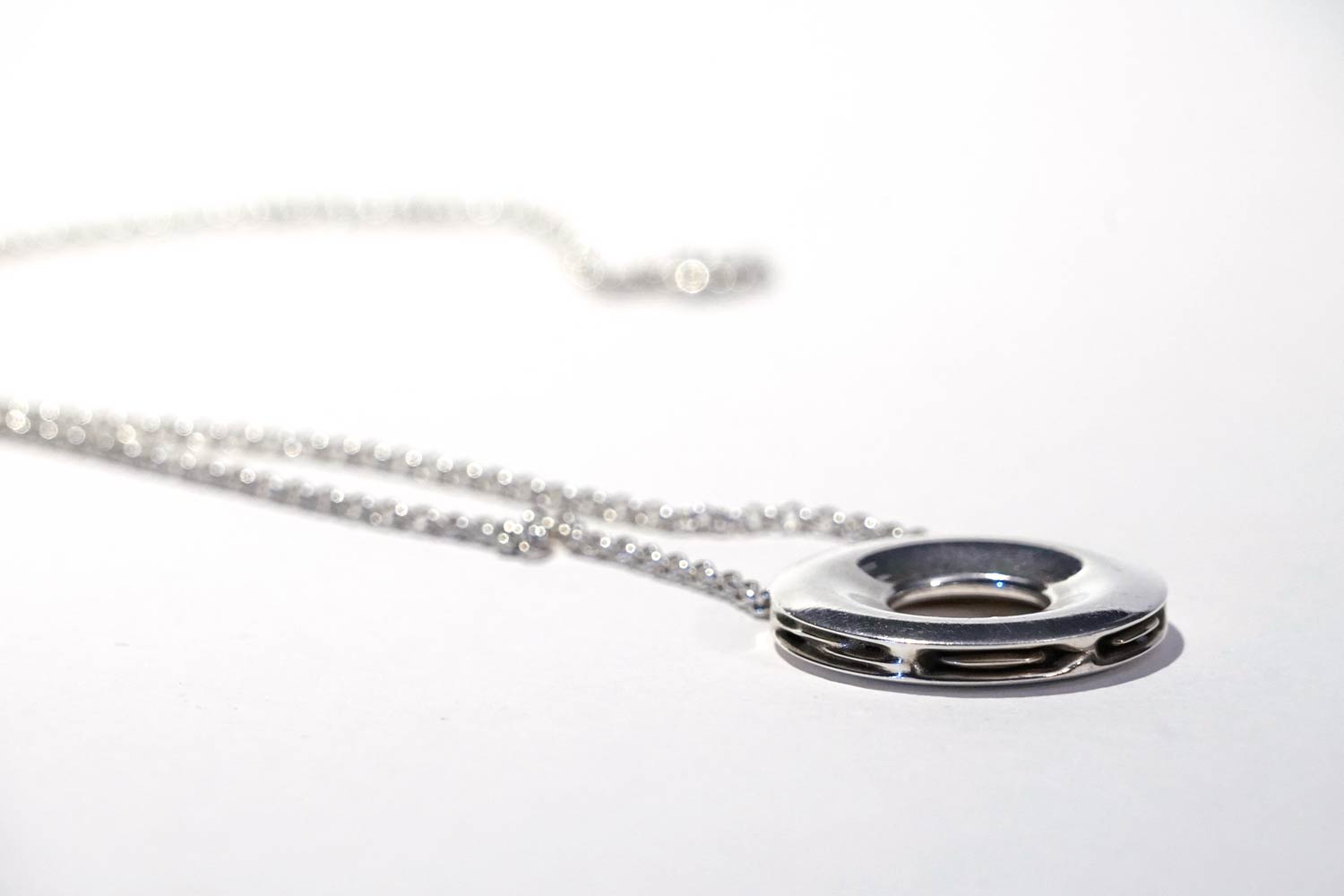 polished silver pendant with chain, left
